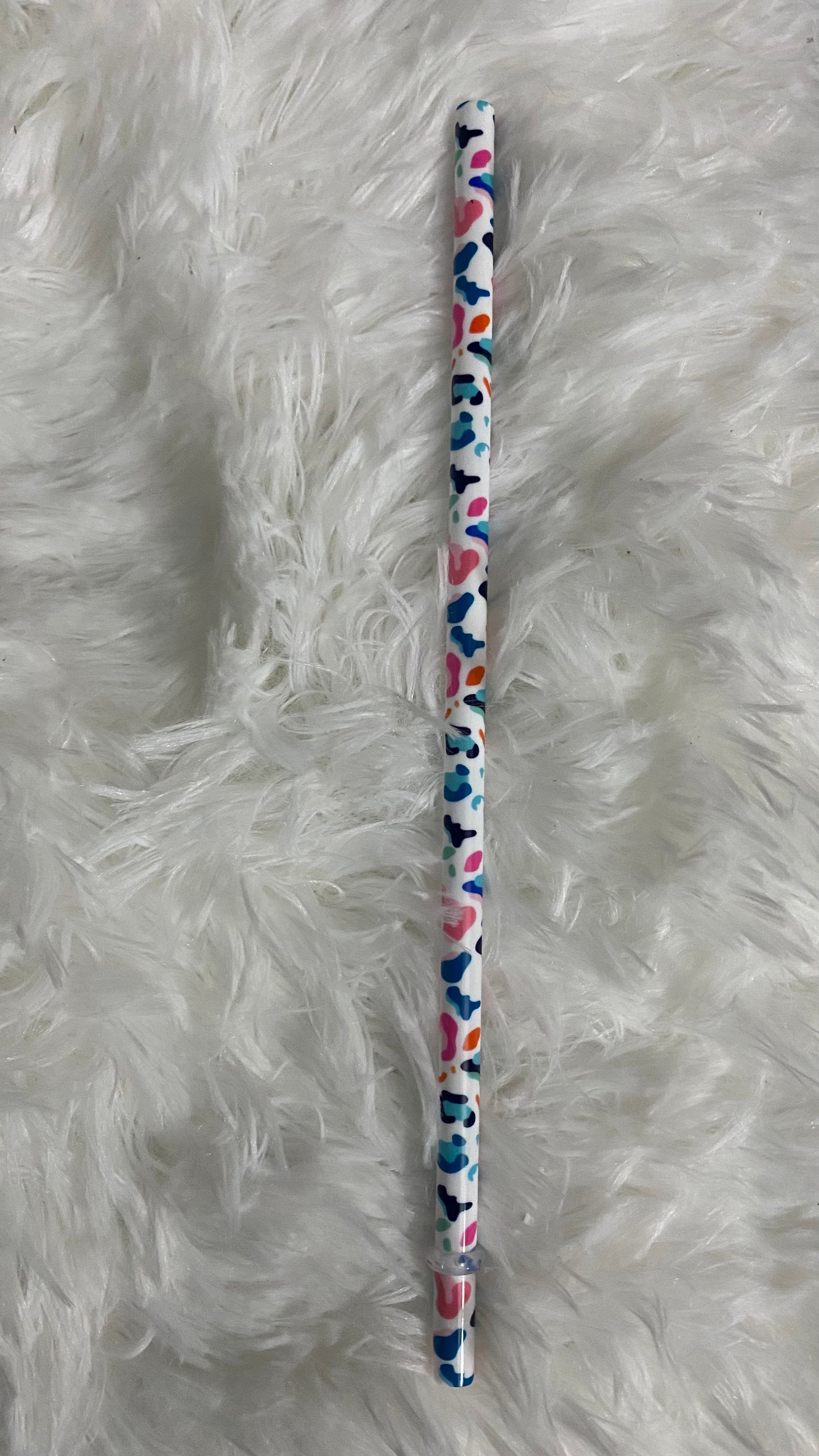 SEMI-HARD PLASTIC STRAW THAT HAS COLORED CHEETAH PRINT WRAPPED AROUND IT WITH STOPPER